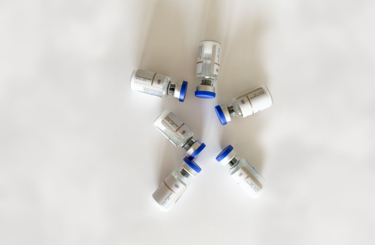 Flat lay of six medical vials forming a circle on a white background.
